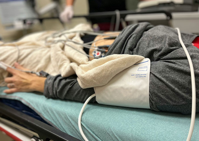 Person lying on hospital bed receiving medical care, illustrating impact of someone missing in life situations.