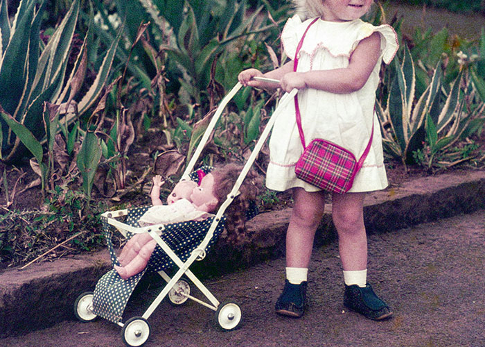 Young child pushing a doll in a stroller, illustrating dark secrets people found out that changed family views.