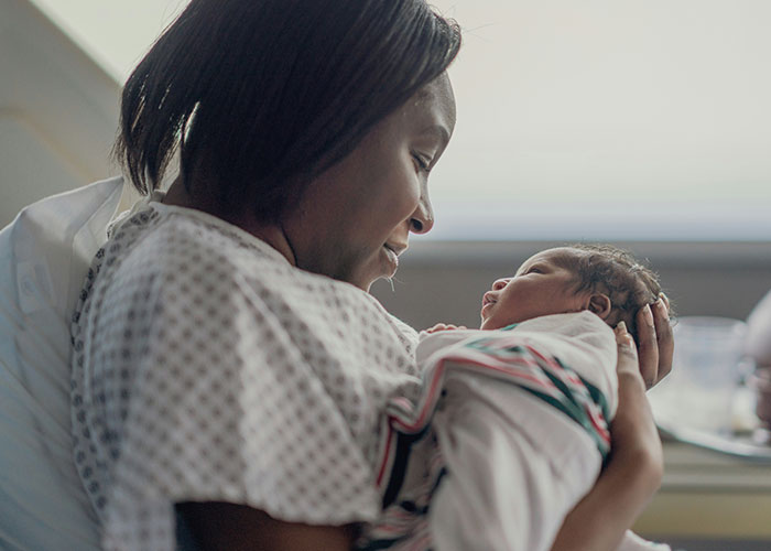 Mother gently holding her newborn baby, illustrating emotional moments tied to dark family secrets discovered.