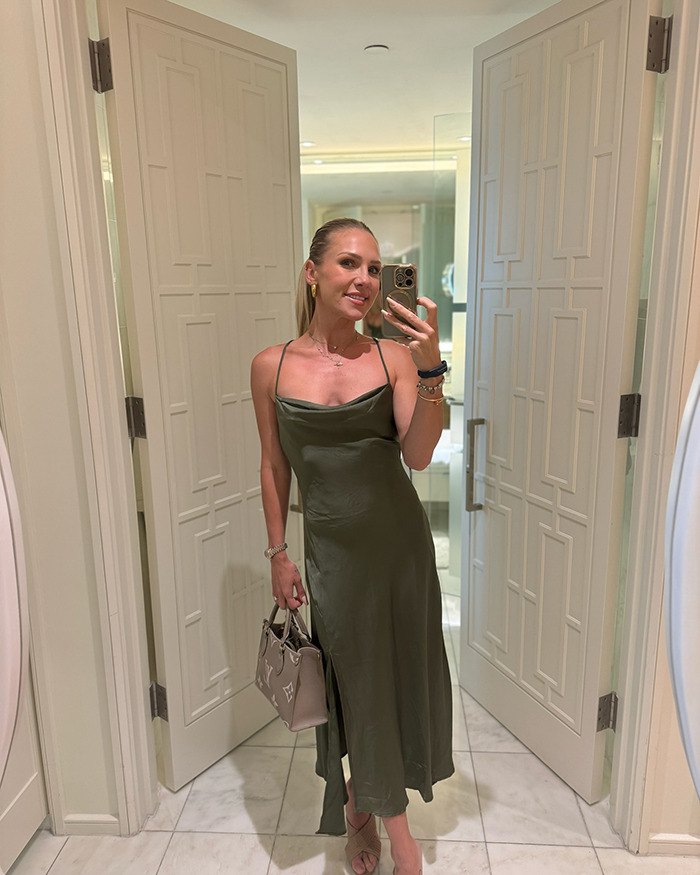 Dancing With The Stars pro taking a mirror selfie in an olive green dress, addressing trolls about her 3YO son's feminine appearance.