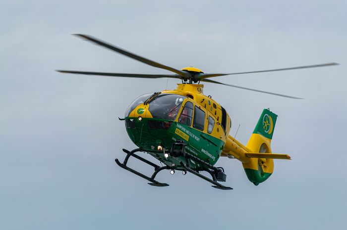 Yellow and green helicopter in flight representing emergency events that caused people to lose all their savings in a single moment