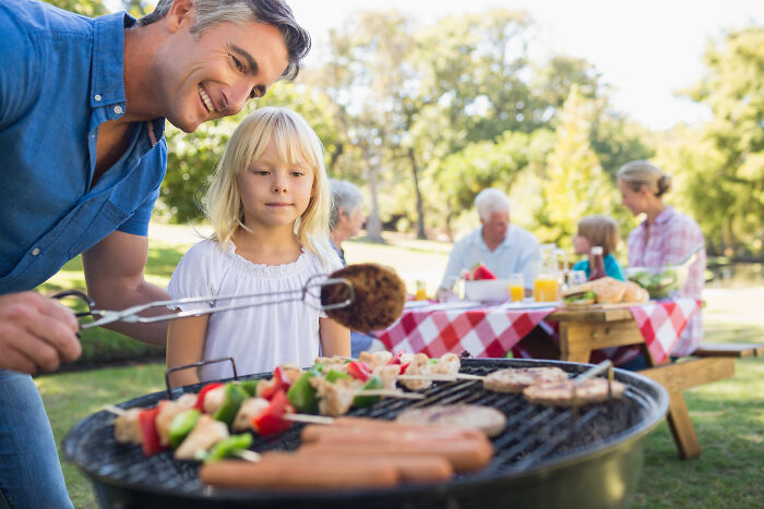 Family enjoying a summer BBQ outdoors with grilled food, highlighting therapy dog restrictions at family gatherings. Family enjoying a summer BBQ outdoors with grilled food, highlighting therapy dog restrictions at family gatherings.