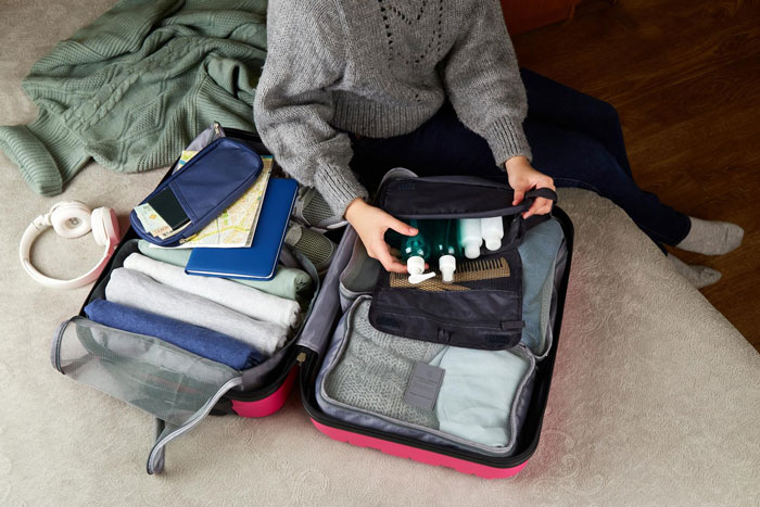 Teen packing suitcase, preparing to break free from feeling like a prisoner babysitting autistic sibling at home. Teen packing suitcase, preparing to break free from feeling like a prisoner babysitting autistic sibling at home.
