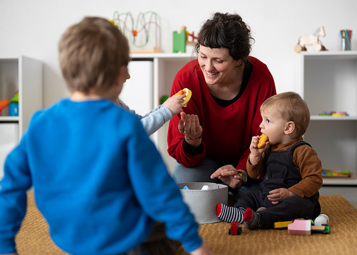 Woman playing with her kids at home while interacting with another child in a cozy indoor play area.