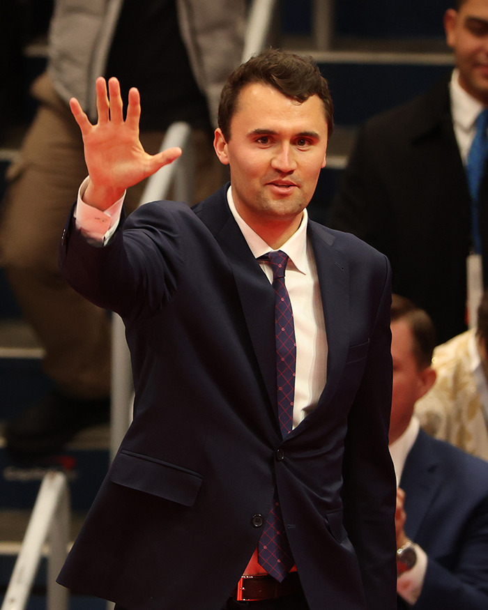 Man in a suit waving to a crowd, related to South Park viewers enraged over eerie episode about Charlie Kirk.