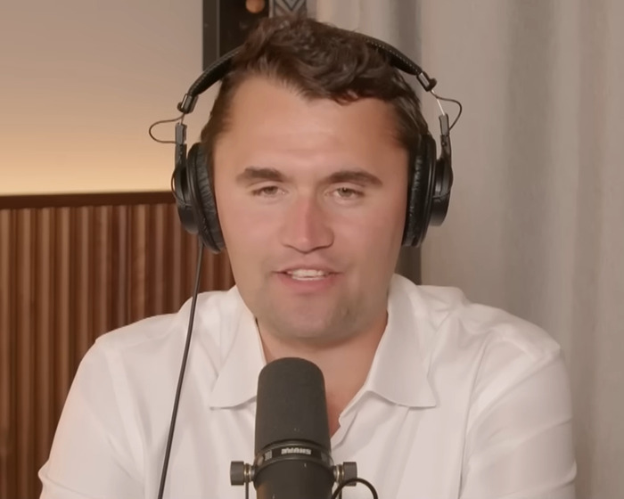 Man wearing headphones and white shirt speaking into a microphone during a podcast about South Park viewers enraged episode.