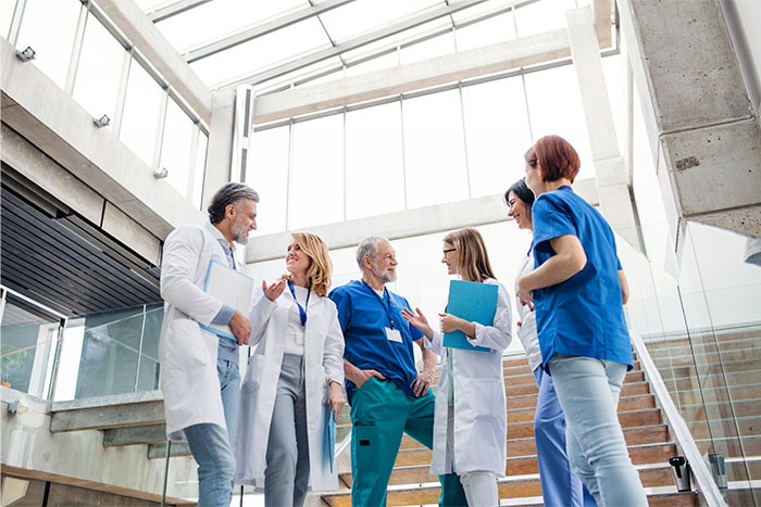 Group of medical professionals in a bright lobby discussing unusual ways people found out their partner was cheating.