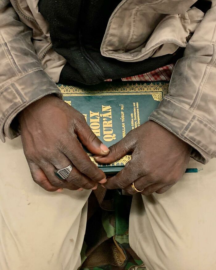 Person on New York subway holding the Quran, showcasing unique and meaningful items people carry in their hands.