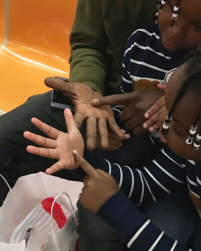 Children and adult on New York subway play with hands, highlighting people taking the subway in New York with cute and funny moments.