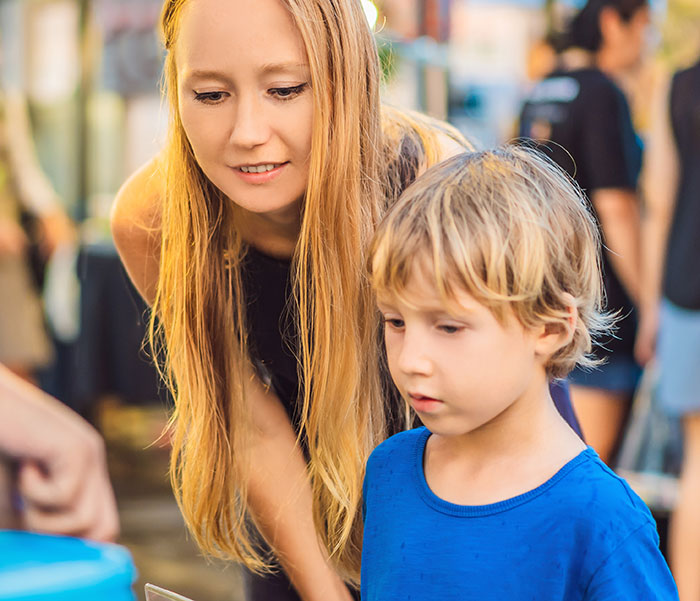 Young kid with nut allergy grabbing a food sample while a worker nearby is being blamed for the situation. Young kid with nut allergy grabbing a food sample while a worker nearby is being blamed for the situation.