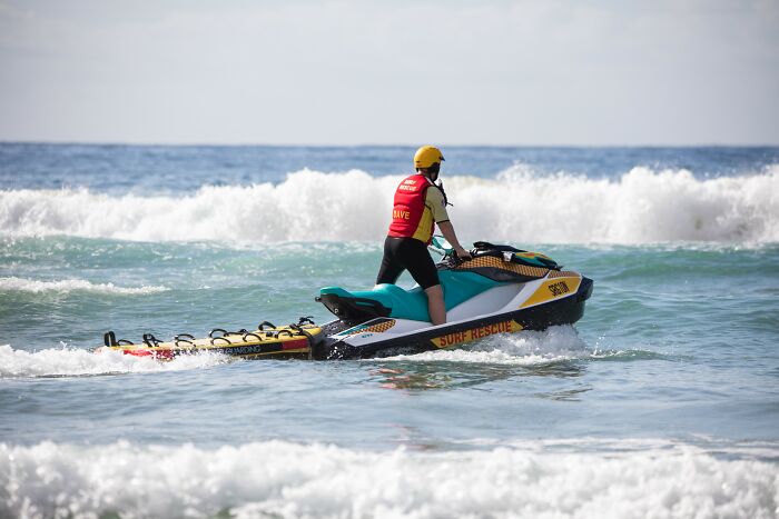 Lifeguard on rescue jet ski in ocean waves, symbolizing patients who defied medical odds and survived against all chances.
