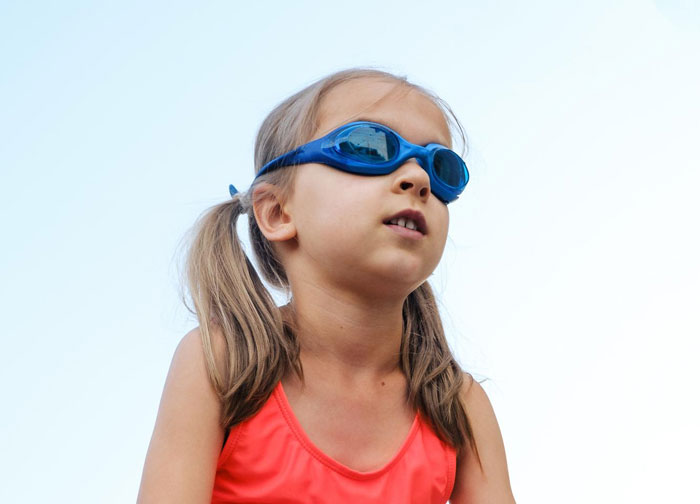 Young girl in modest swimwear and blue goggles, highlighting concerns about male swim teacher and swim lesson issues. Young girl in modest swimwear and blue goggles, highlighting concerns about male swim teacher and swim lesson issues.