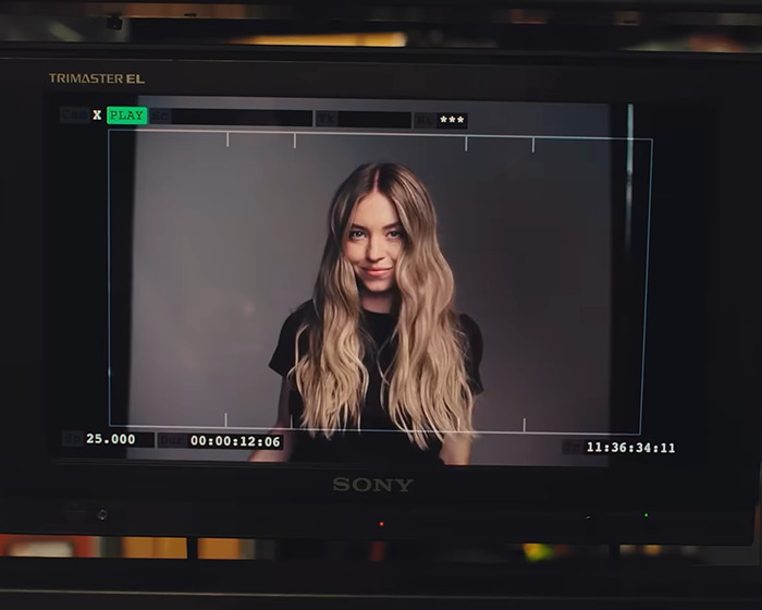 Sydney Sweeney posing for a new Jimmy Choo ad campaign, captured on a professional video monitor. Sydney Sweeney posing for a new Jimmy Choo ad campaign, captured on a professional video monitor.