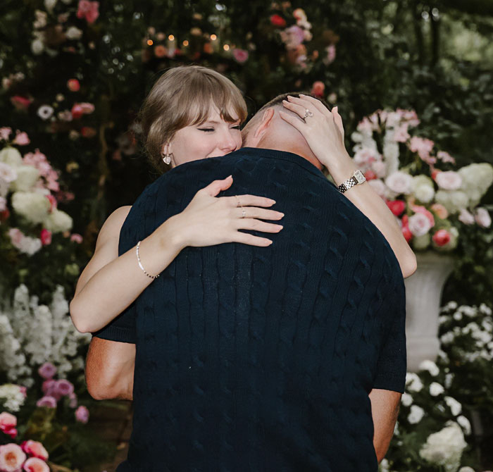 Woman hugging a man at an outdoor wedding with floral decorations, relating to Taylor Swift wedding viral reaction.