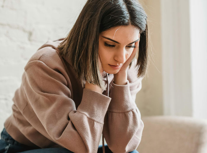 Young woman looking distressed and thoughtful, reflecting on best friend&rsquo;s affair and relationship betrayal.