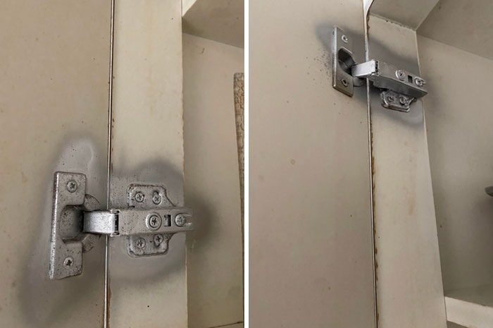 Worn and rusted cabinet hinges inside a neglected rental property showing poor landlord maintenance.