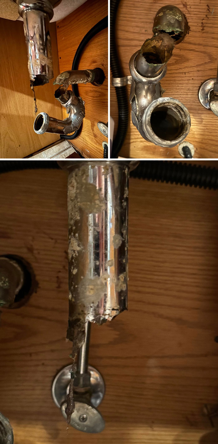 Corroded and broken plumbing pipes under a sink showing landlord neglect causing renters to want to run away.