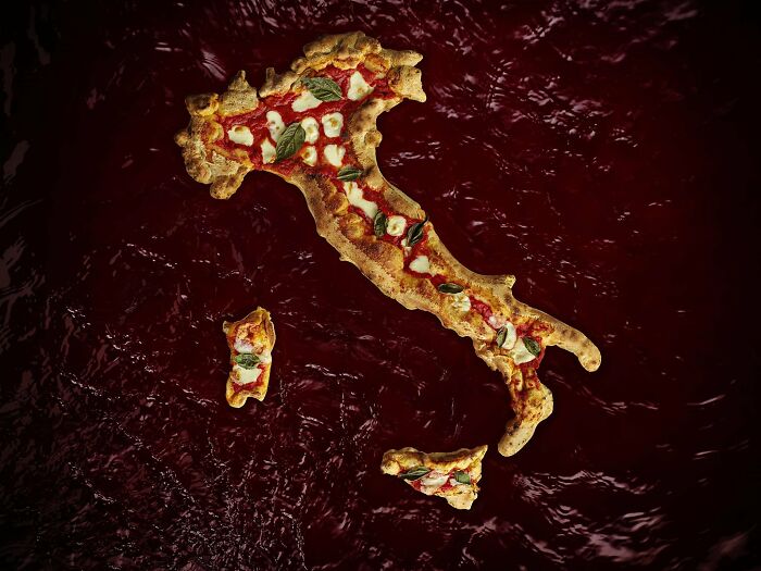 Map of Italy creatively made as a pizza with toppings over a dark red background, illustrating funny and bad maps.
