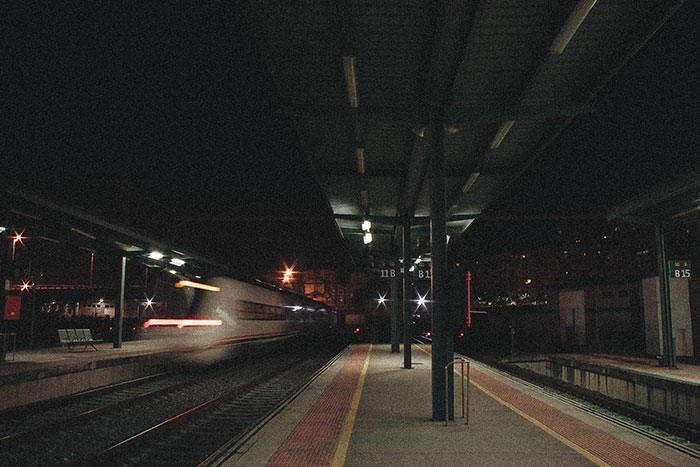 Nighttime train station with a speeding train, illustrating things that look awesome in movies but are terrible in real life.