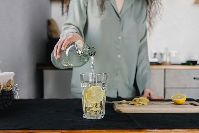 Person pouring water into a glass with lemon, illustrating things that look awesome in movies but are terrible in real life.