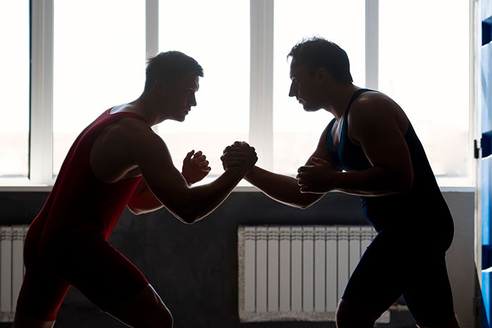 Two men wrestling indoors, illustrating things that look awesome in movies but are terrible in real life.