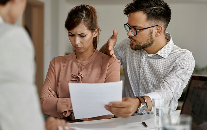 Man unintentionally making a woman feel threatened during a serious discussion at work, illustrating key signs men do without realizing.