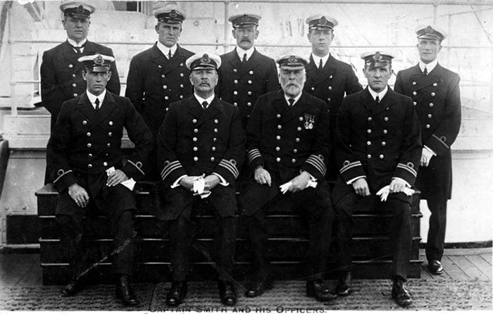Group of Titanic officers in uniform posing on the ship's deck in a rare historical photo from the Titanic archives.
