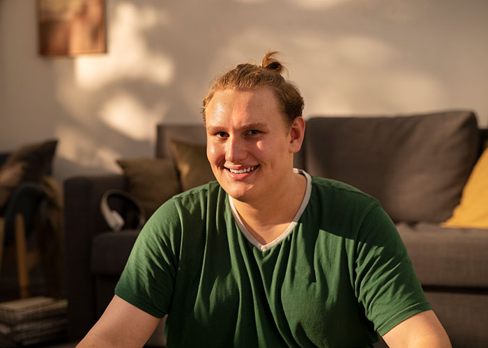 Young man smiling at home, representing lies that changed someone else's life for better or worse.