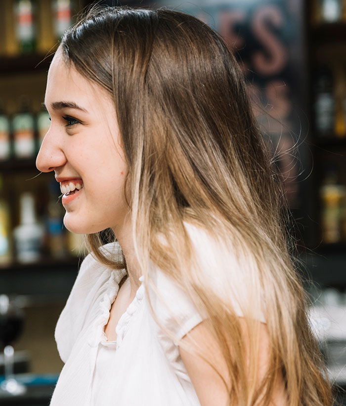Young woman smiling in a casual setting illustrating 42 lies that changed someone else’s life for better or worse.