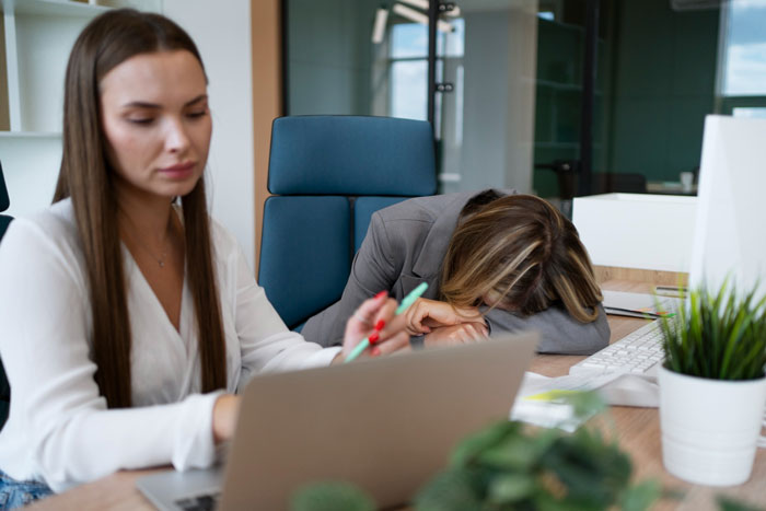 Stressed employee overwhelmed by toxic bosses in an office setting, highlighting workplace conflict and disciplinary challenges.