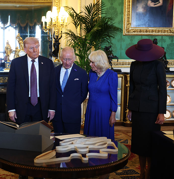 Melania Trump wearing a black outfit with a large hat at a formal event in the UK, outfit attracting attention and mockery. Melania Trump wearing a black outfit with a large hat at a formal event in the UK, outfit attracting attention and mockery.