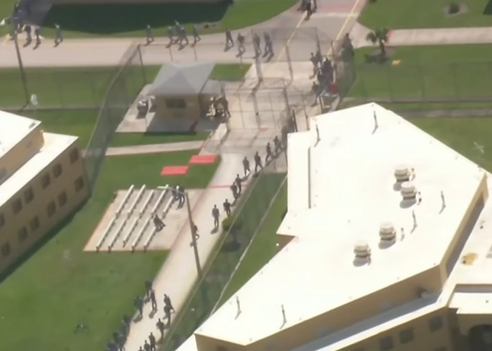 Aerial view of detainees walking inside a fenced facility reportedly missing from ICE records at Alligator Alcatraz.