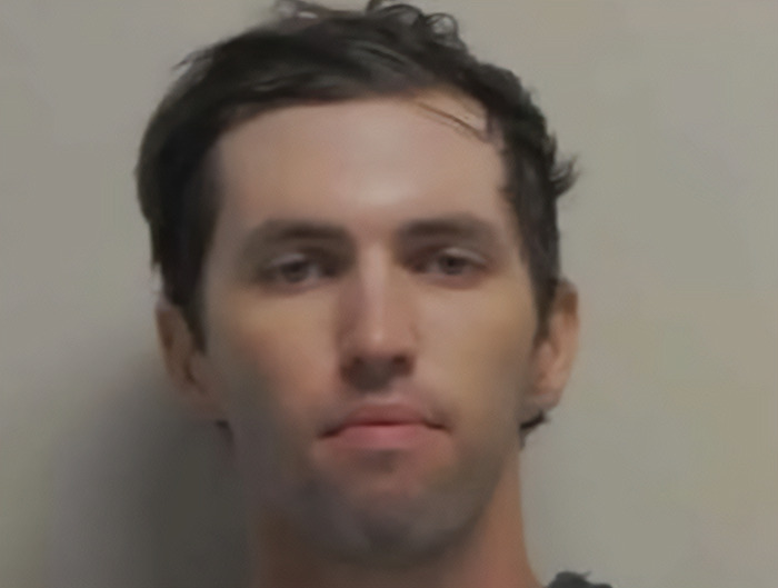 Tyler Robinson, suspect linked to Charlie Kirk case, appears in court with a neutral expression against a plain background.