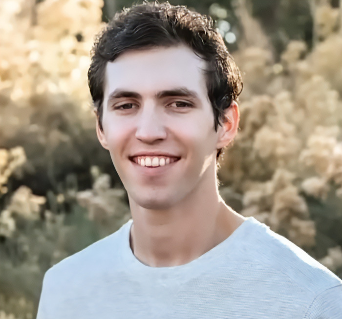 Tyler Robinson outdoors wearing a white shirt, people notice an eerie detail about the Charlie Kirk suspect appearance.