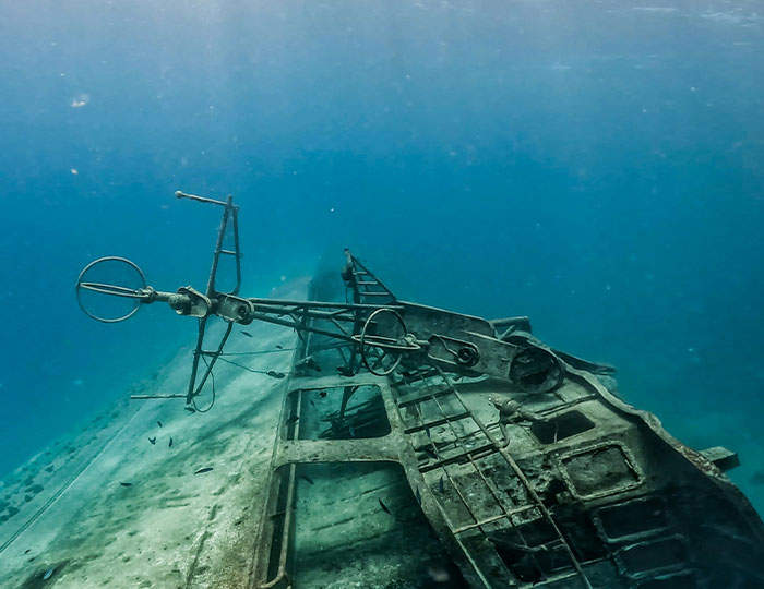 Sunken shipwreck underwater surrounded by fish, illustrating bizarre and fascinating historical events.