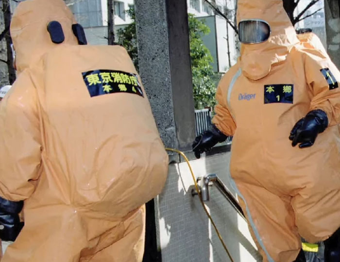 Two people in bulky hazmat suits performing a safety procedure, illustrating bizarre and fascinating historical events.
