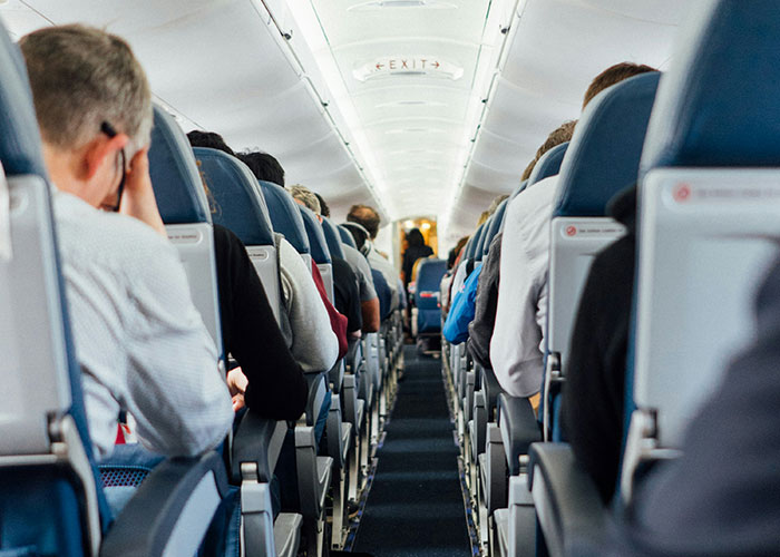 Passengers seated inside an airplane cabin, illustrating unexpected industry secrets outsiders don’t know about travel.