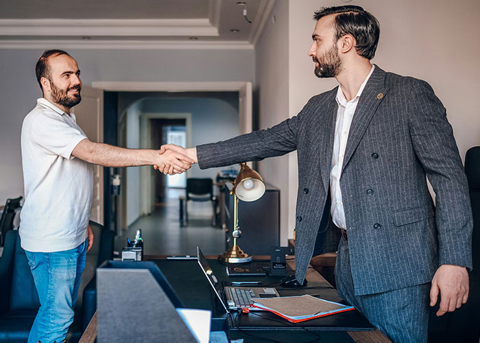 Two men shaking hands in an office setting, symbolizing industry secrets and professional insider knowledge.