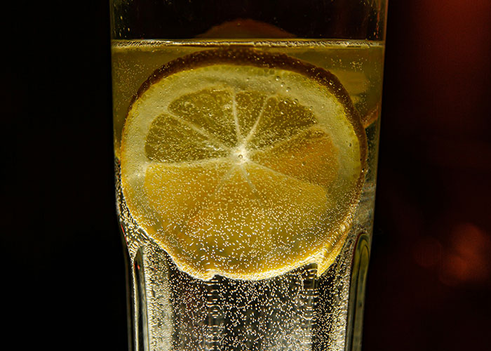 Close-up of a lemon slice in sparkling water, highlighting unexpected industry secrets in beverage presentation.