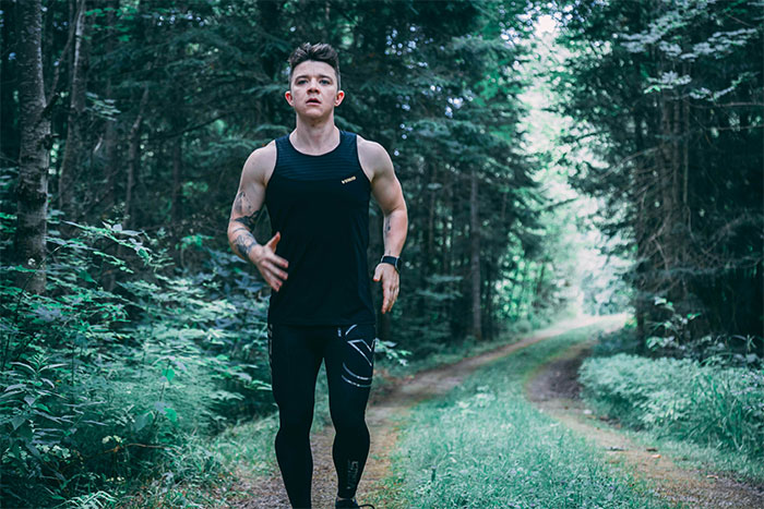 Young man running on a forest path, representing exploration in bizarre and paranormal experiences people can’t explain.