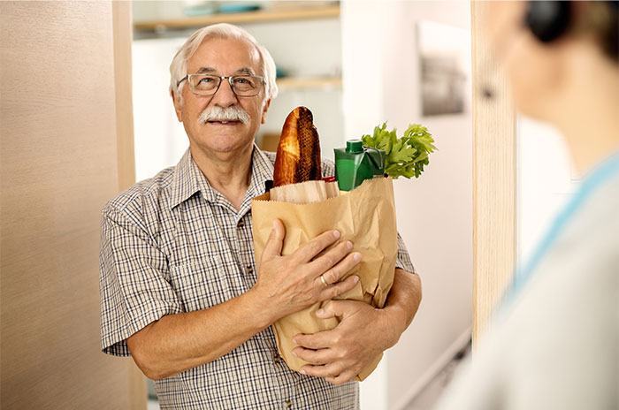 Elderly man holding groceries at the door, a subtle representation of bizarre and paranormal experiences theme.