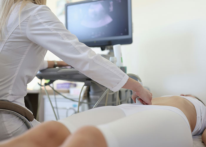 Doctor performing ultrasound scan on patient’s abdomen, illustrating unique body quirks and human body fascination.