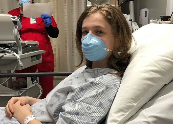 Young patient wearing a mask lying in hospital bed, illustrating weird body quirks and fascinating human body traits.