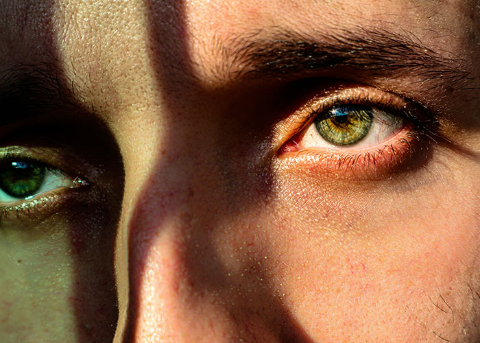 Close-up of a person's face showing green eyes and skin details, illustrating fascinating human body quirks.