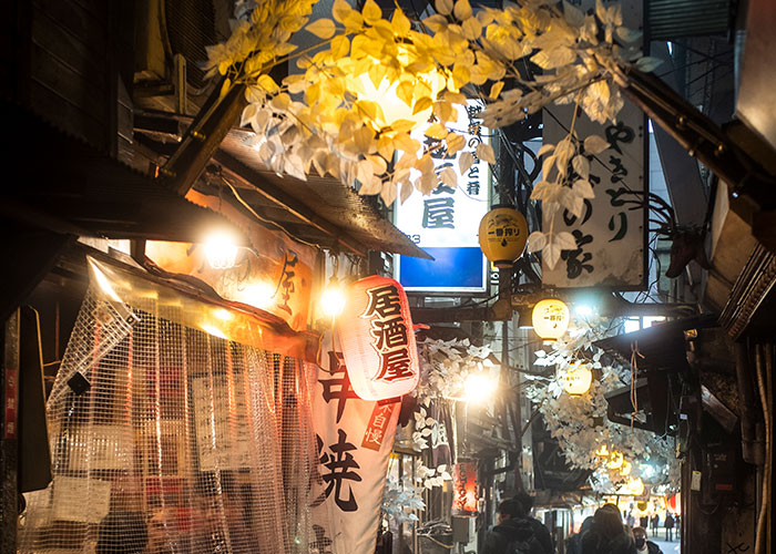 Narrow alley decorated with lanterns and banners, capturing a chaotic and overwhelming vacation atmosphere.