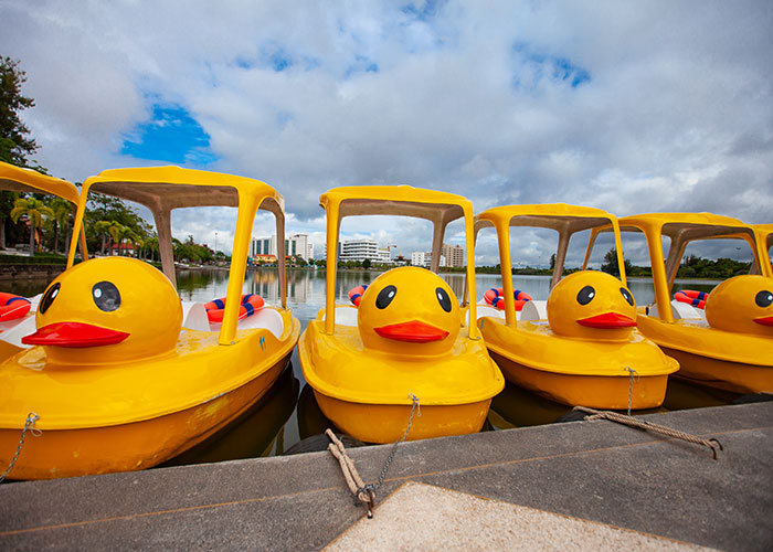 Yellow duck-shaped pedal boats docked by the water, representing vacations that turned into trips to hell experiences.