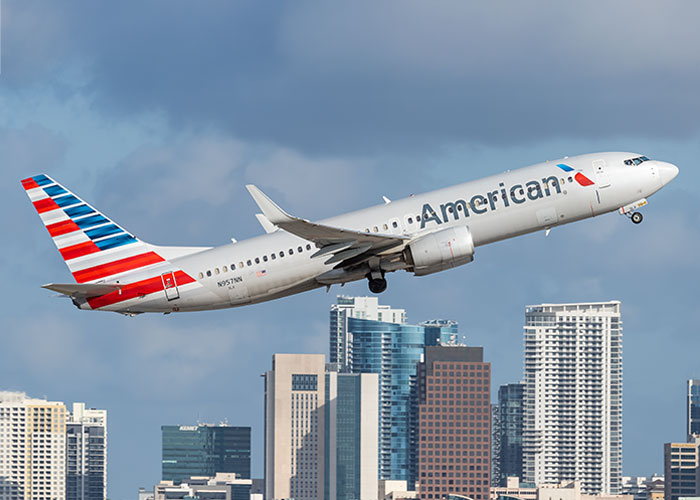 American Airlines airplane taking off over city skyline, symbolizing vacations that ended up being trips to hell.