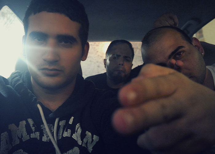 Three men in a car with serious expressions, illustrating vacations that ended up being trips to hell experiences.