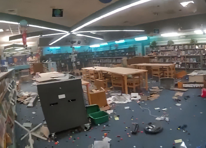 Library interior showing scattered debris and overturned furniture, illustrating chaos linked to mothers turning in their children to police.