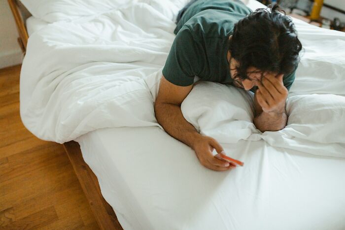 Man lying on bed using smartphone, reflecting on relationship tips for happy marriages and maintaining a great bond.